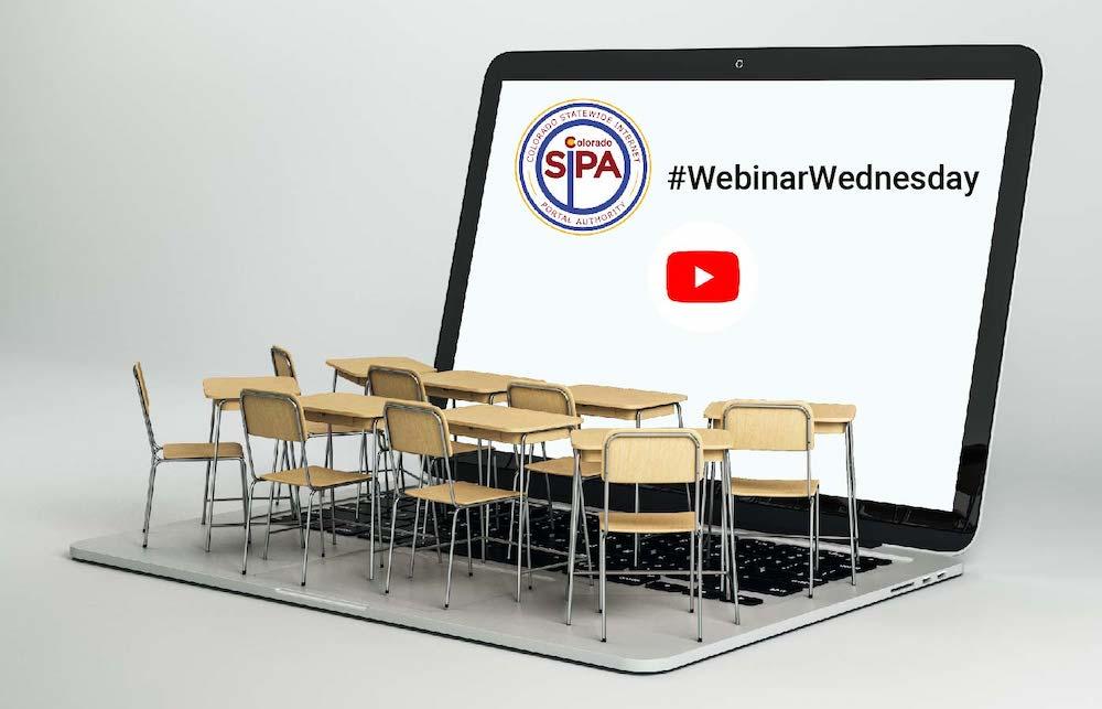 School chairs with attached desks sitting on a laptop keyboard facing the screen showing SIPA's logo and the YouTube logo